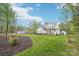 Charming two-story white home with a well-manicured lawn, lush trees, and beautiful landscaping at 6006 Waxhaw Crossing Dr, Waxhaw, NC 28173