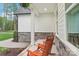 Inviting covered front porch featuring rocking chairs, stone accents and white siding for relaxing outdoors at 6006 Waxhaw Crossing Dr, Waxhaw, NC 28173