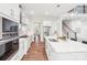Modern, all-white kitchen with stainless steel appliances, stylish lighting, and a large center island at 6006 Waxhaw Crossing Dr, Waxhaw, NC 28173