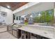 Entertain with this outdoor kitchen featuring stainless appliances, countertop seating, and views of the pool and backyard at 6006 Waxhaw Crossing Dr, Waxhaw, NC 28173