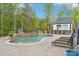 Backyard pool with a stone waterfall feature, a pool house with an outdoor bar, and lounge chairs at 6006 Waxhaw Crossing Dr, Waxhaw, NC 28173