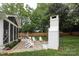 Charming backyard features an outdoor fireplace, a screened porch, and dining area at 6036 Sharon Acres Rd, Charlotte, NC 28210