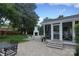 Beautiful backyard showcasing a screened porch, a fire pit, and stone paved patios at 6036 Sharon Acres Rd, Charlotte, NC 28210