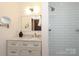 Bright bathroom features a marble vanity and a subway-tiled shower with white grout at 6036 Sharon Acres Rd, Charlotte, NC 28210