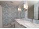 Stylish bathroom with patterned wallpaper, double sinks, and white marble countertop at 6036 Sharon Acres Rd, Charlotte, NC 28210