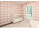 Lovely Bedroom features pink plaid wallpaper, a white crib, and plantation shutters at 6036 Sharon Acres Rd, Charlotte, NC 28210