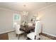 Well-lit dining room showcasing a classic dining table with seating for four under a chandelier at 6036 Sharon Acres Rd, Charlotte, NC 28210