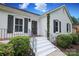 Close-up of the front porch featuring white painted steps, a black front door, and wrought iron railings at 6036 Sharon Acres Rd, Charlotte, NC 28210