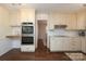 Charming kitchen features white cabinetry, stainless steel appliances, and hardwood flooring at 6036 Sharon Acres Rd, Charlotte, NC 28210