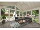 Inviting sunroom features vaulted ceiling, neutral decor, comfortable seating, and backyard views at 6036 Sharon Acres Rd, Charlotte, NC 28210