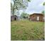 Expansive backyard with a shed, brick house, and lush greenery offering great potential at 6115 Amberly Ln, Charlotte, NC 28213