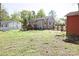 A spacious backyard featuring a wooden deck, a fence, and mature trees at 6124 Old Plank Rd, Charlotte, NC 28216