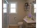 Bathroom featuring a shower, toilet, a sink vanity, and a modern light fixture and shelving at 6124 Old Plank Rd, Charlotte, NC 28216