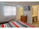 Bright bedroom with a modern dresser, TV, patterned curtains, and access to an ensuite bathroom at 6124 Old Plank Rd, Charlotte, NC 28216