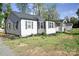 Well-kept single-Gathering house featuring light gray siding and black shutters, surrounded by lush greenery at 6124 Old Plank Rd, Charlotte, NC 28216