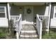 Charming front porch with security camera, wreath on the door, and plants decorating the entrance at 6124 Old Plank Rd, Charlotte, NC 28216
