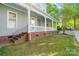 Spacious back porch with painted columns, brick foundation, green lawn, and manicured landscaping at 6165 Caseys Side Way, Fort Mill, SC 29708