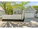 View of the light gray house with a white fence, well-manicured yard, and a two-car garage at 6165 Caseys Side Way, Fort Mill, SC 29708