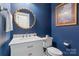 Stylish powder room with navy walls, modern vanity, and unique starburst mirror at 6165 Caseys Side Way, Fort Mill, SC 29708