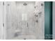 Modern shower with marble tile, a corner seat, and updated fixtures at 6165 Caseys Side Way, Fort Mill, SC 29708