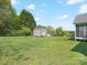 Expansive backyard with a storage shed, mature trees, and lush green grass at 621 Summey Farm Dr, Dallas, NC 28034