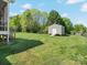 Spacious backyard with a shed, surrounded by lush greenery and mature trees at 621 Summey Farm Dr, Dallas, NC 28034