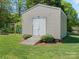 Features a gray shed with double doors, a wooden ramp, and a playset in a grassy backyard at 621 Summey Farm Dr, Dallas, NC 28034