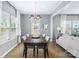 Elegant dining room featuring a rustic table, modern chandelier, and bright windows with view of backyard at 6563 Kinder Ln, Lancaster, SC 29720