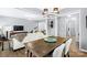 Open-concept dining area with view of living room featuring a rustic table and modern chandelier at 6563 Kinder Ln, Lancaster, SC 29720