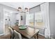 Dining area with a rustic table, modern chandelier, and a view of the adjacent office and neighborhood at 6563 Kinder Ln, Lancaster, SC 29720