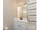 Bathroom features a mirror, vanity, and towel rack in a well-lit, neutral space at 6801 Dumbarton Dr, Charlotte, NC 28210