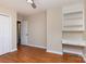 Bedroom with hardwood floors, built-in shelves, and a desk area, providing a functional and stylish space at 6801 Dumbarton Dr, Charlotte, NC 28210