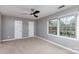 Bedroom with neutral carpet, dual closets, and natural light from the window overlooking the neighborhood at 6801 Dumbarton Dr, Charlotte, NC 28210