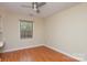 Cozy bedroom with hardwood floors, a ceiling fan, and a window providing natural light at 6801 Dumbarton Dr, Charlotte, NC 28210