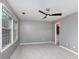 Bright bedroom with neutral carpet, a ceiling fan, and a view of the backyard through the window at 6801 Dumbarton Dr, Charlotte, NC 28210