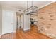 Open dining area features hardwood floors, brick accent wall, and views into the kitchen, creating an inviting space at 6801 Dumbarton Dr, Charlotte, NC 28210