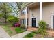 Charming two-story townhome featuring a brick facade, black shutters, and a well-maintained front yard with flowering bushes at 6801 Dumbarton Dr, Charlotte, NC 28210