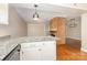 Bright kitchen featuring white cabinetry, granite countertops, and hardwood floors, open to the living area with a brick fireplace at 6801 Dumbarton Dr, Charlotte, NC 28210