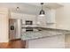 Well-lit kitchen with white cabinetry, stainless steel appliances, granite countertops, and hardwood floors at 6801 Dumbarton Dr, Charlotte, NC 28210