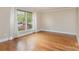 Bright living room featuring hardwood floors, neutral walls, and a large window with views of the landscaped front yard at 6801 Dumbarton Dr, Charlotte, NC 28210