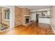 Inviting living room with a brick fireplace and hardwood floors open to a kitchen with stainless steel appliances at 6801 Dumbarton Dr, Charlotte, NC 28210