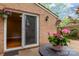 Cozy brick patio with flowers and sliding glass doors leading to a bright living area at 6801 Dumbarton Dr, Charlotte, NC 28210