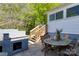 Outdoor patio with a table, chairs, stairs, and brick bbq pit overlooking the lawn at 702 Hazel Ave, Kannapolis, NC 28083