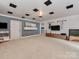 Spacious basement with neutral carpet, white brick wall, and entertainment center at 7048 Delta Lake Dr, Charlotte, NC 28215
