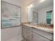 Bright bathroom featuring double sinks, granite countertops, and modern fixtures beneath a large mirror at 7048 Delta Lake Dr, Charlotte, NC 28215