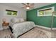 Cozy bedroom with a stylish green accent wall, plush rug, and plenty of natural light from the windows at 7048 Delta Lake Dr, Charlotte, NC 28215