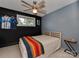 Serene bedroom with a striking black accent wall and a comfortable bed illuminated by a modern ceiling fan at 7048 Delta Lake Dr, Charlotte, NC 28215