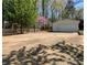 Spacious driveway leads to a detached garage, surrounded by trees and nature at 7048 Delta Lake Dr, Charlotte, NC 28215