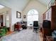 Bright home office with vaulted ceilings, large arched window, and built-in wooden cabinets at 7184 Seagrass Cir, Denver, NC 28037