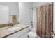 Well-lit bathroom featuring a granite countertop, white cabinets, and a shower-tub combo with patterned curtain at 7186 Barleywood Dr, Locust, NC 28097
